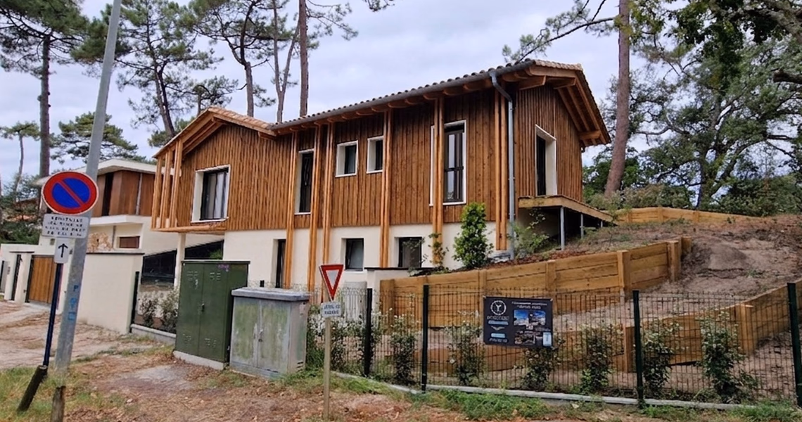 Maison individuelle contemporaine à étage avec bardage en bois vertical et toiture en tuiles.