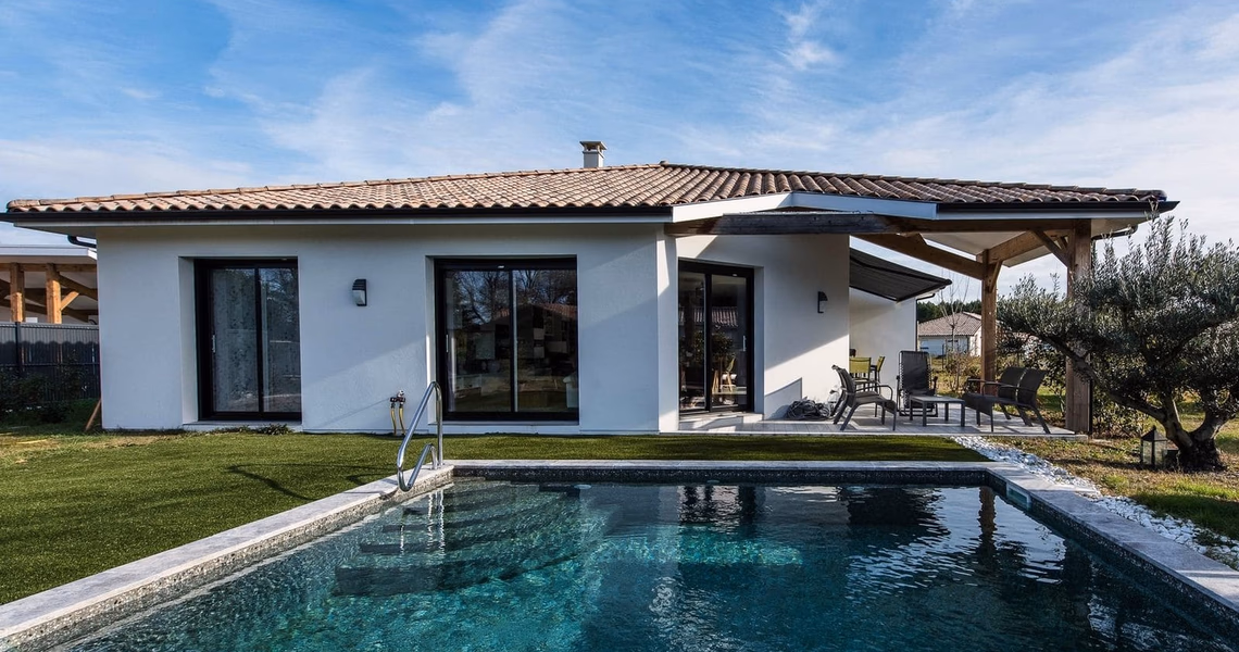Maison de plain-pied blanche à toiture en tuiles avec piscine et terrasse couverte à Lit-et-Mixe.