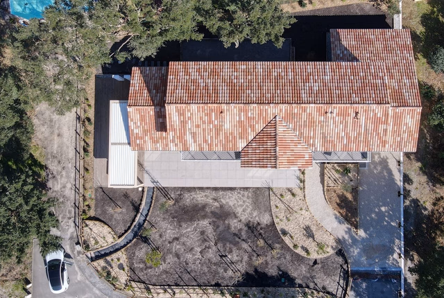 Vue aérienne d'une grande villa aux toits en tuiles romanes entourée d'arbres à Messanges.