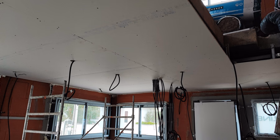 Pose de faux plafond en plaques de plâtre et passage des gaines électriques sur un chantier de rénovation à Capbreton par Landes Habitat