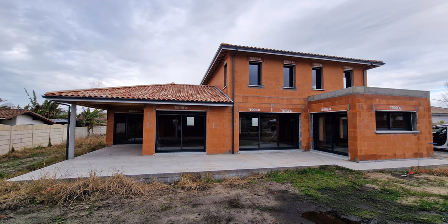 Vue arrière d'une maison contemporaine à étage avec extension toit plat en construction à Tosse par Landes Habitat.