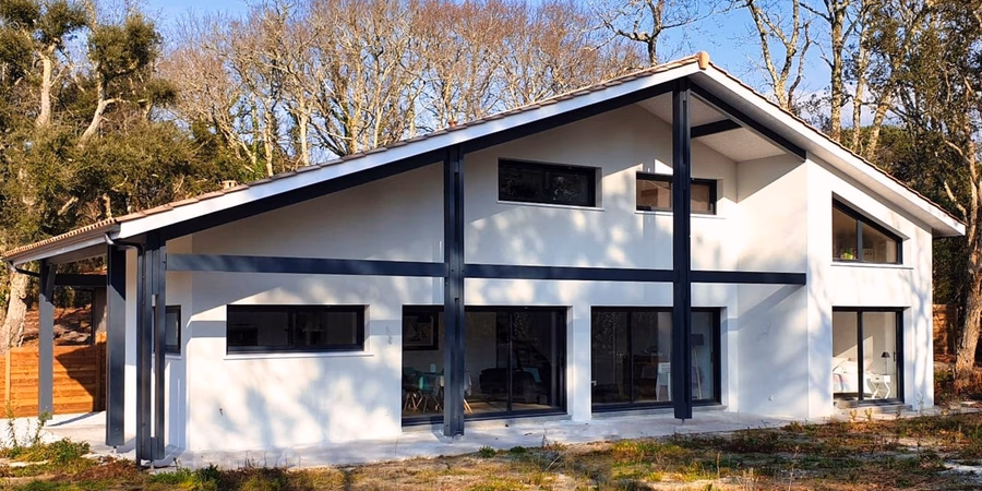 Façade moderne d'une maison familiale à Moliets avec bardage foncé et larges baies vitrées