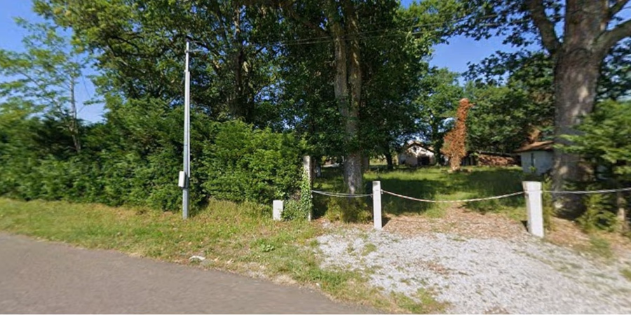 Terrain arboré de 893 m² à Mézos (40), route de Bias, accès gravillonné et clôture à chaîne