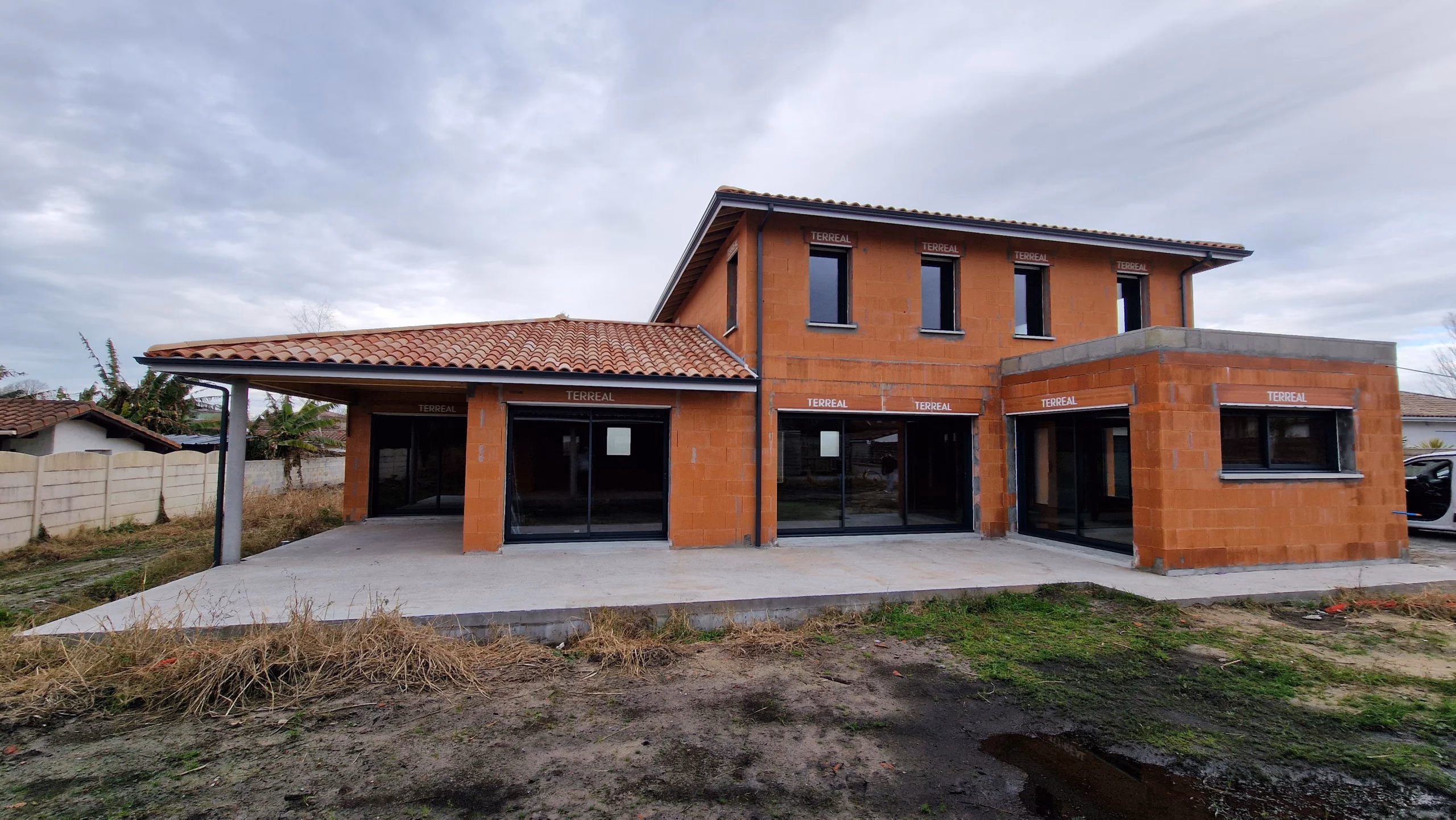 Vue arrière d'une maison contemporaine à étage avec extension toit plat en construction à Tosse par Landes Habitat.