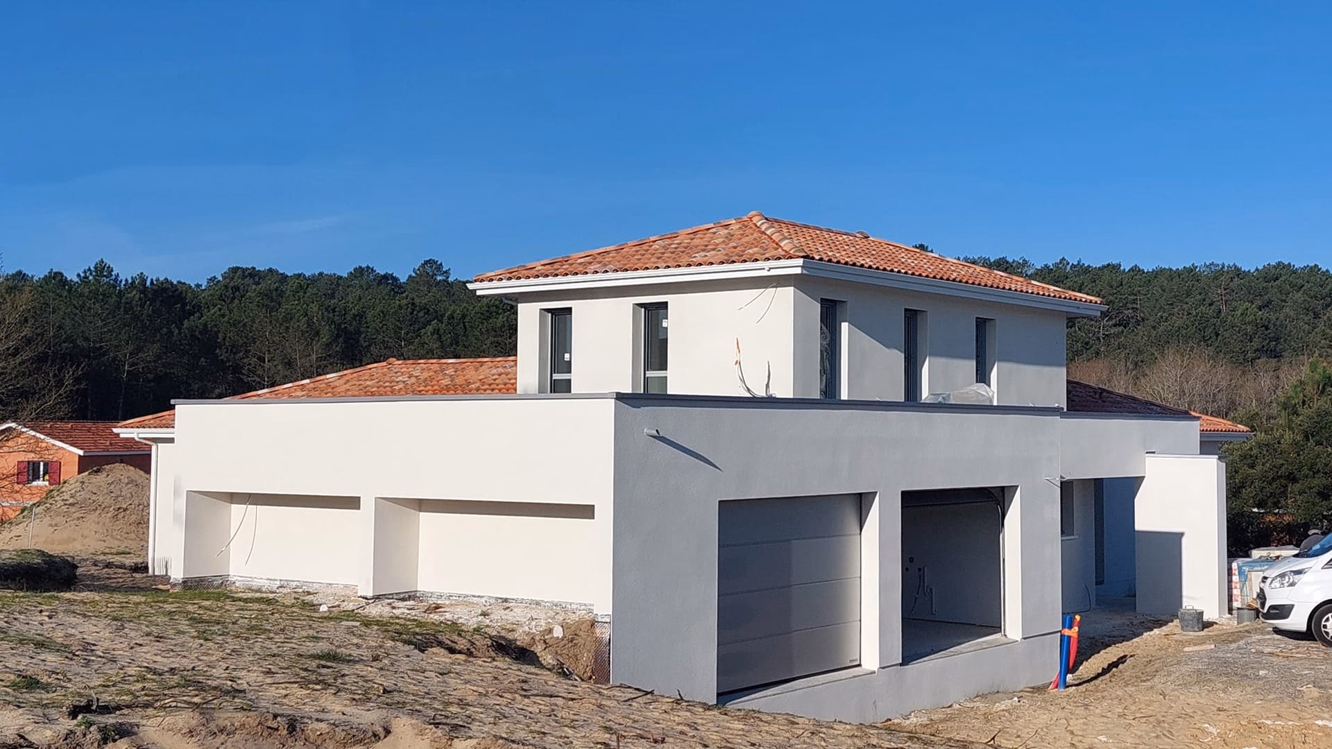 Vue d'une maison en construction Lit-et-Mixe avec enduit blanc et toiture mixte