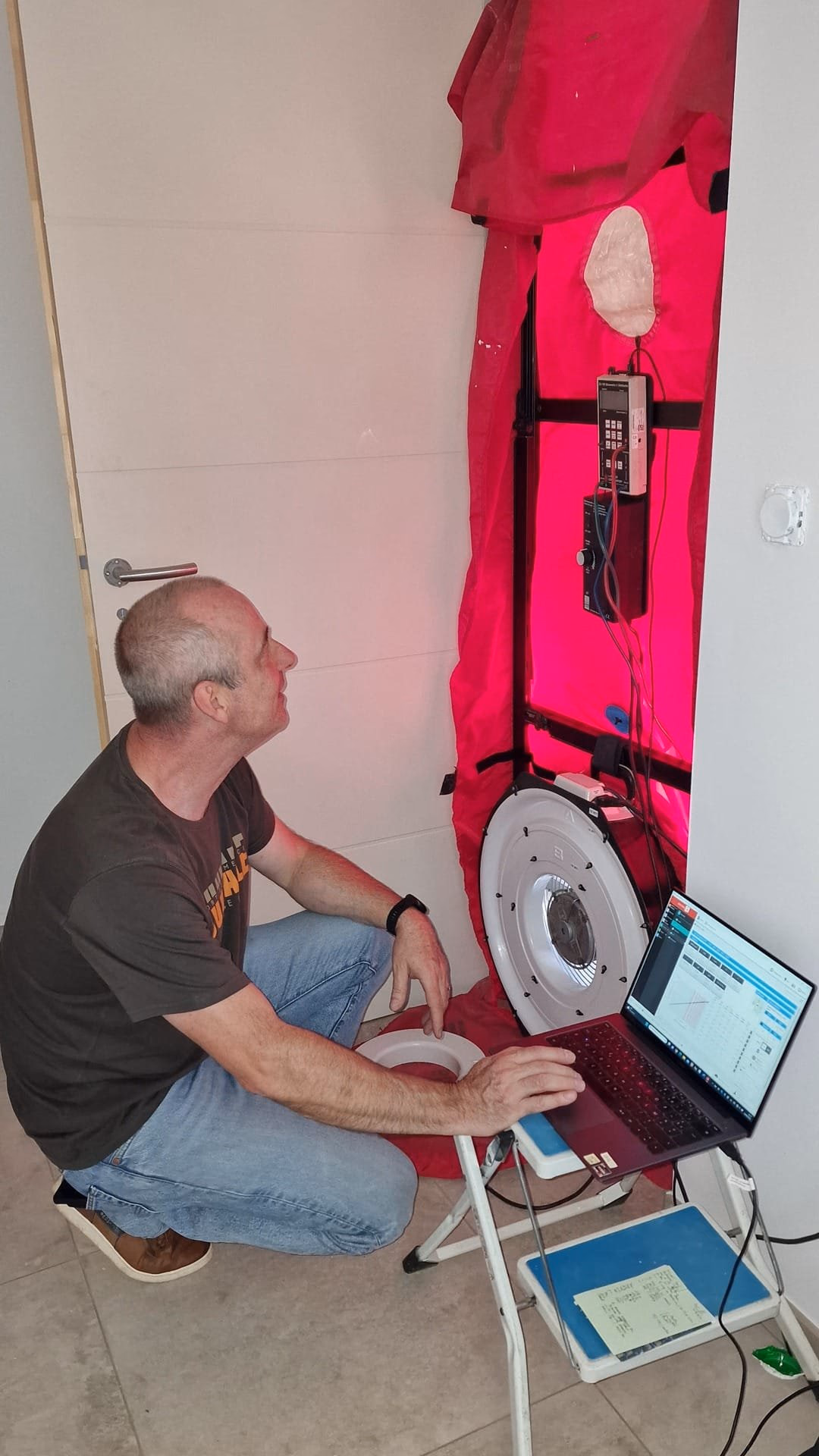 Technicien réalisant un test d’infiltrométrie avec une porte soufflante dans une maison neuve
