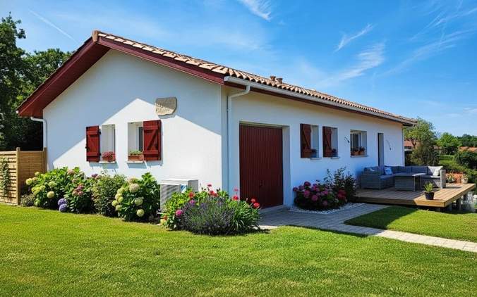 Maison individuelle de plain-pied avec terrasse en bois et jardin fleuri construite à Urcuit par Landes Habitat.