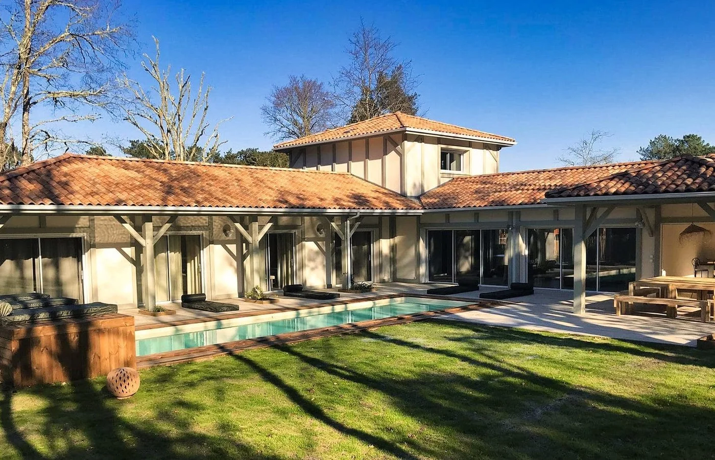 Villa contemporaine en U avec piscine, terrasse en bois et patio extérieur construite par Landes Habitat à Moliets