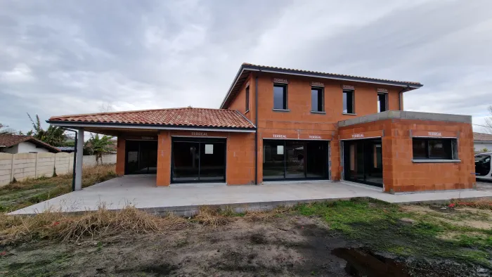 Vue arrière d'une maison contemporaine à étage avec extension toit plat en construction à Tosse par Landes Habitat.