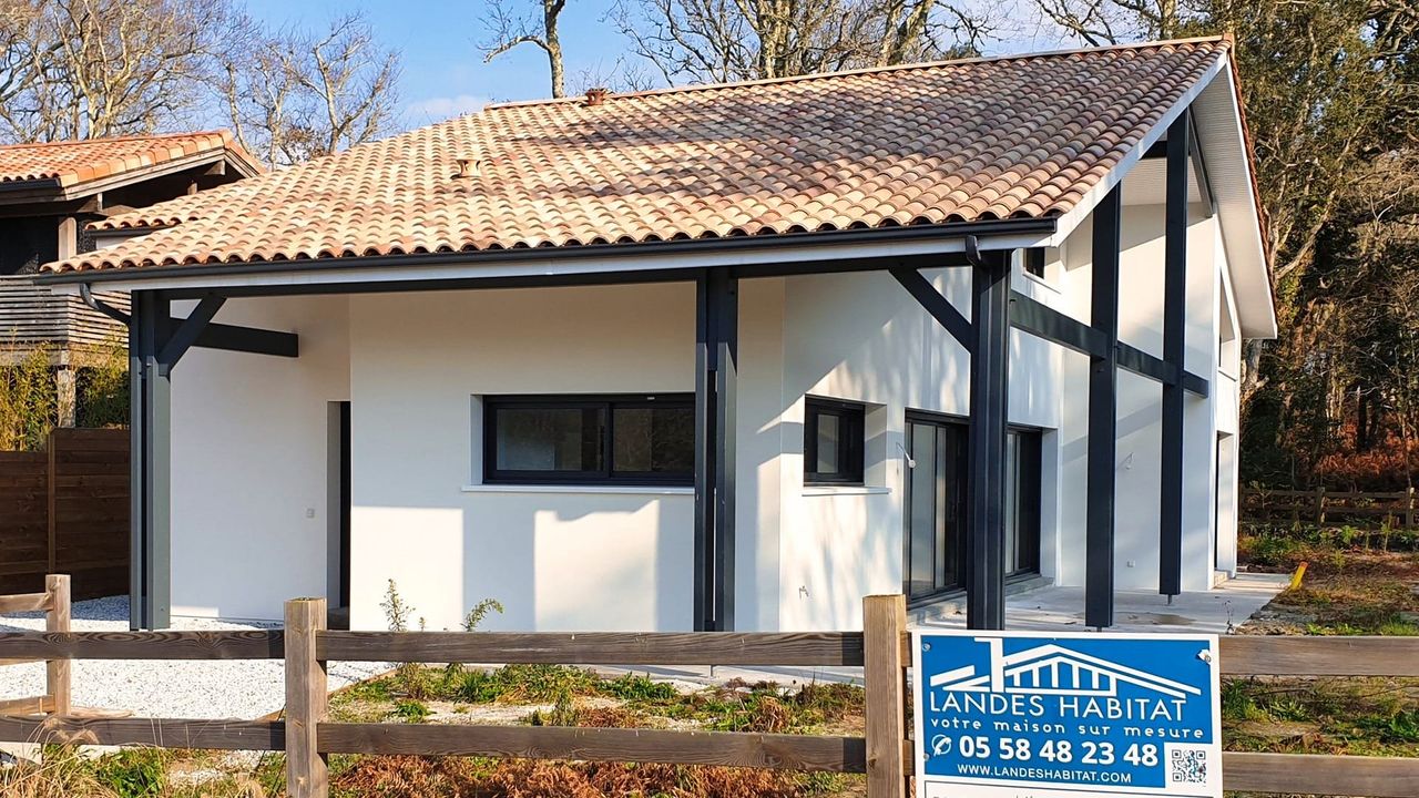 Vue latérale d'une maison moderne à Moliets avec bardage contrasté et panneau Landes Habitat