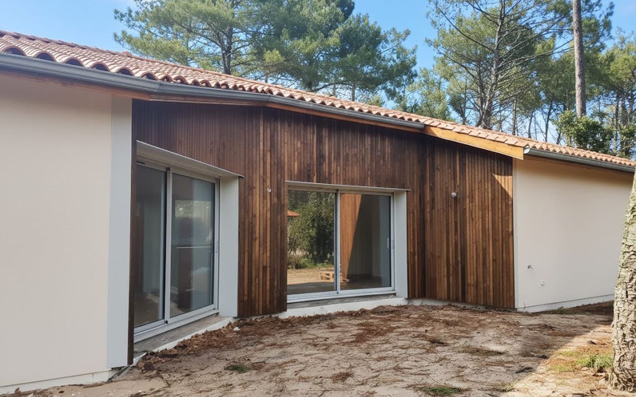 Façade finition bois et enduit, menuiseries aluminium K-LINE, construction Landes Habitat.