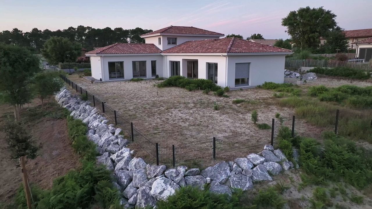 Vue aérienne de la maison avec toiture en tuiles rouges, jardin naturel et enrochement à Lit-et-Mixe