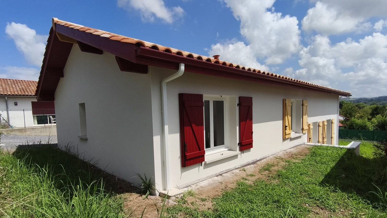 Maison traditionnelle à Ustaritz avec volets rouges et bois