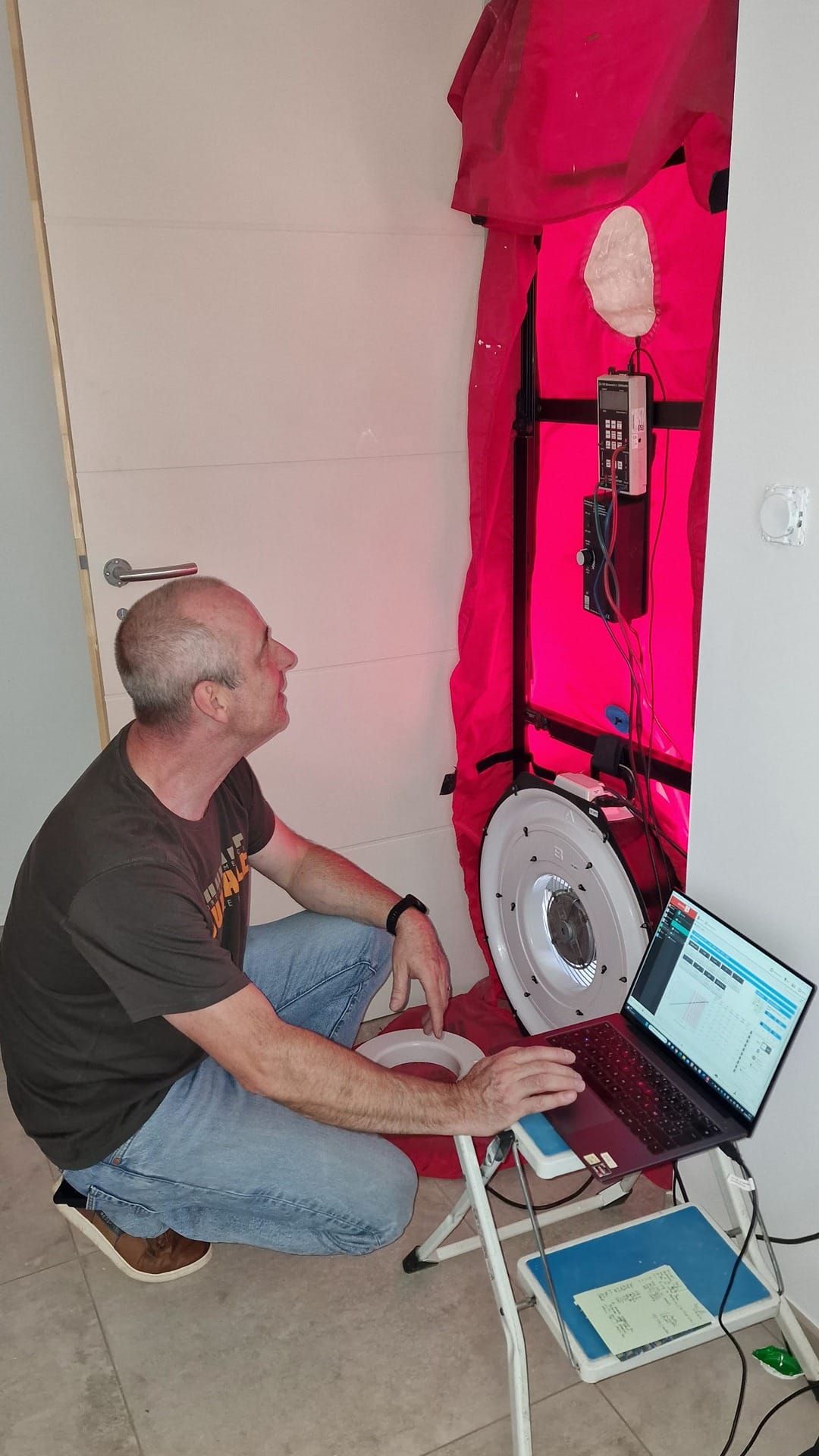 Technicien réalisant un test d’infiltrométrie avec une porte soufflante dans une maison neuve