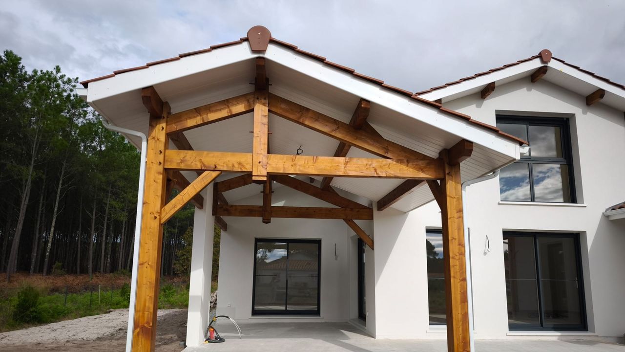 Détail du porche d'entrée avec charpente traditionnelle en sapin traité apparente, sur une maison à Vielle-Saint-Girons.