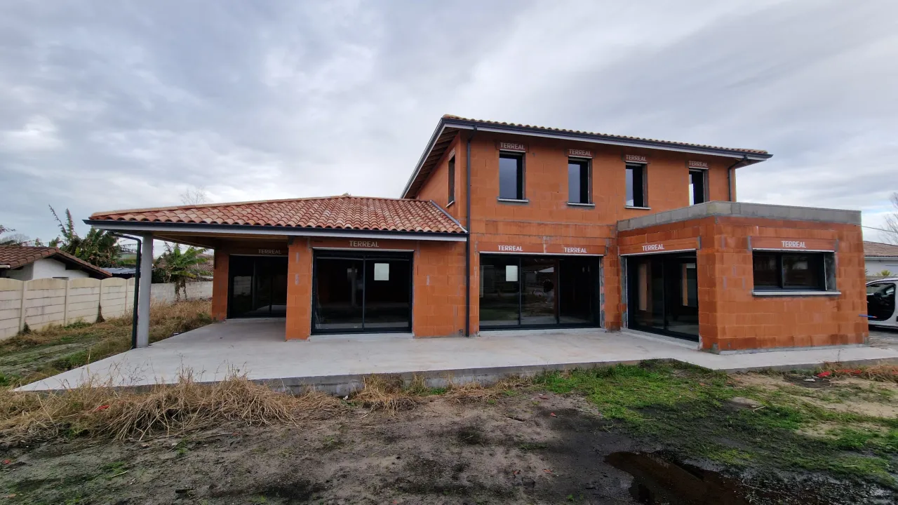 Vue arrière d'une maison contemporaine à étage avec extension toit plat en construction à Tosse par Landes Habitat.
