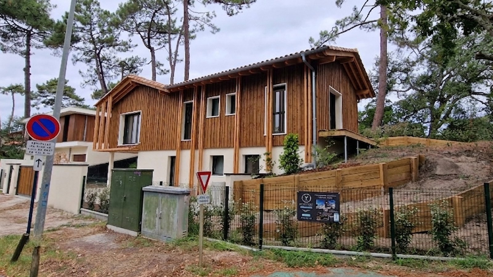 Vue de la façade avant d'une maison individuelle contemporaine avec bardage bois vertical, construite par Landes Habitat.